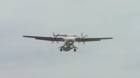 Propeller plane approaching runway with gear down and lights on. Aircraft slowly Stock Footage 318453084