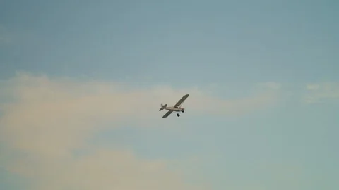 Propeller plane flying in blue sky at sunrise with orange clouds 5K Stock Footage 128519645