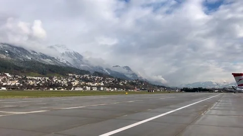 A propeller plane takes off from runway 26 at Innsbruck Airport, Austria. Stock Footage 82798481
