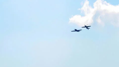 Propeller planes flying in formation through blue sky with clouds 库存影片 345363905