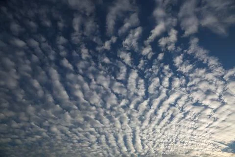 Properly deployed clouds creating pattern on sunset sky Stock Photos