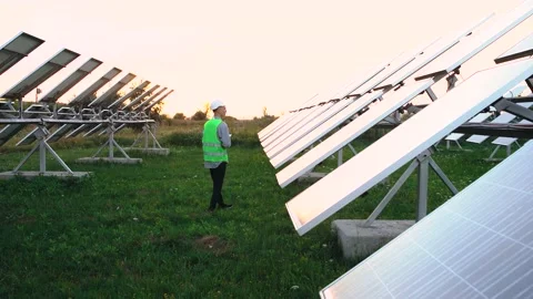 Properly equipped Caucasian engineer checks the solar panels and notes the Stock Footage 140204916