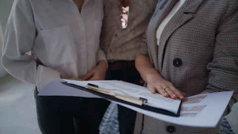 Property Agent Shows Flat Plans to Couple Considering Purchase Stock-Footage 311817613