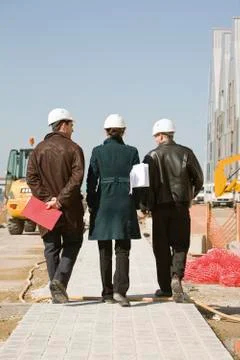Property developers walking at construction site, rear view Stock Photos