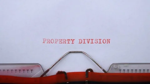 Property division - phrase printed on an old typewriter in red letters, close up Видео 129535901