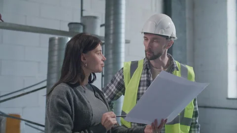 Property Owner and Contractor Discussing Architectural Drawing on Site Stock Footage 332249113