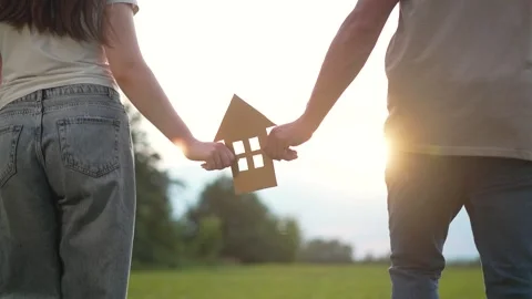 Property ownership dream shared by happy couple in green field. Hands hold paper Stock Footage 345958388