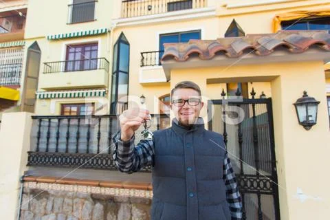 Property, ownership, new home and people concept - young man with keys standing Stock Photos