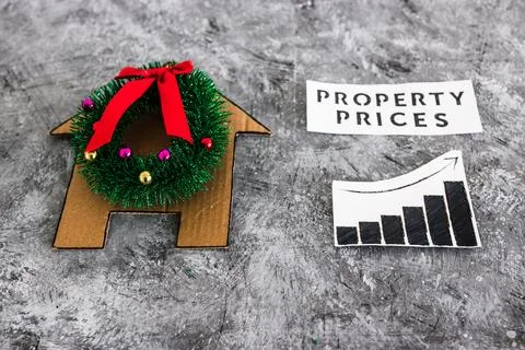 Property prices text and graph with stats going up next to cardboard house .. Stock Photos