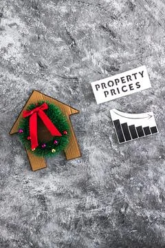 Property prices text and graph with stats going down next to cardboard hous.. Foto stock