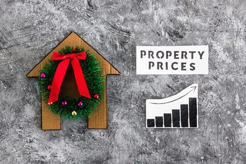 Property prices text and graph with stats going up next to cardboard house .. Stock Photos