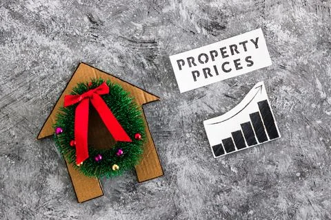 Property prices text and graph with stats going up next to cardboard house .. Stock Photos