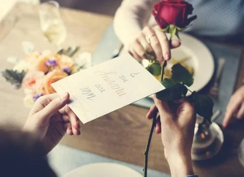 Proposing with a red rose at the dinner table Stock Photos