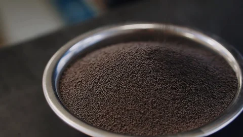 Proppant in a bowl. Propping agent with dark colors for oil industry. Stock Footage 115428866
