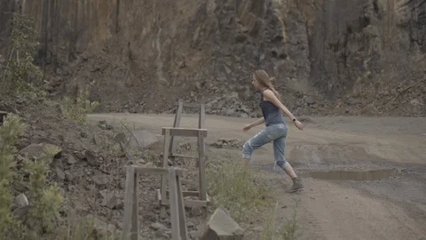 ProRes 4:2:2 log, slow motion footage. Young woman walking in basalt career. Stock Footage 109333769