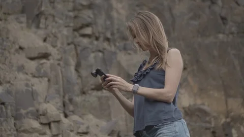 ProRes 4:2:2 log, slow motion footage. Young woman walking in basalt career. Stock Footage 109497115