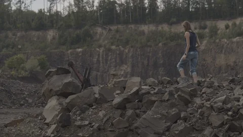 ProRes 4:2:2 log, slow motion footage. Young woman walking in basalt career. Stock Footage 109522619