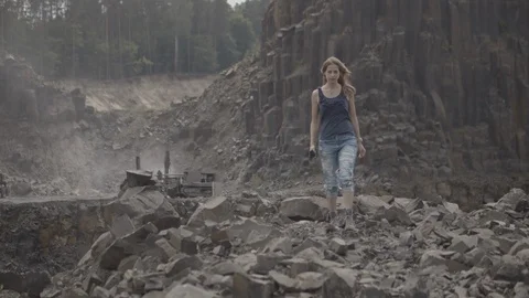 ProRes 4:2:2 log, slow motion footage. Young woman walking in basalt career. Stock Footage 109524946