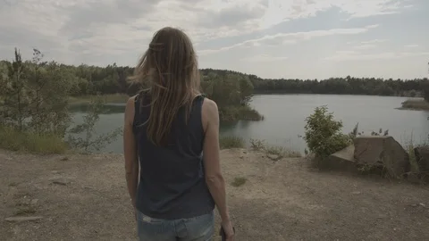 ProRes 4:2:2 log, slow motion footage. Young woman walking in the wood near lake Stock Footage 109542305