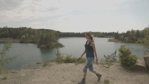 ProRes 4:2:2 log, slow motion footage. Young woman walking in the wood near lake Stock Footage 109543459