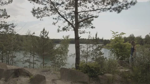 ProRes 4:2:2 log, slow motion footage. Young woman walking in the wood near lake Video stock 109545117