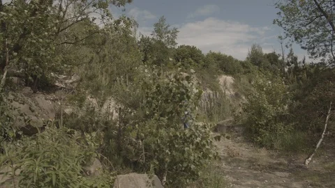 ProRes 4:2:2 log, slow motion footage. Young woman walking in the wood near lake Stock Footage 109546663