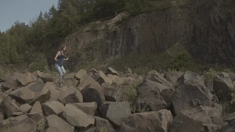 ProRes 4:2:2 log, slow motion footage. Young woman walking in basalt career. Stock Footage 109592217