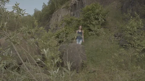 ProRes 4:2:2 log, slow motion footage. Young woman walking in basalt career. Stock Footage 109791365