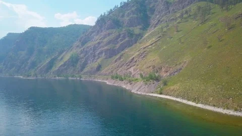 ProRes. Steam train passes through the mountains along the shore. Stock Footage 84364577