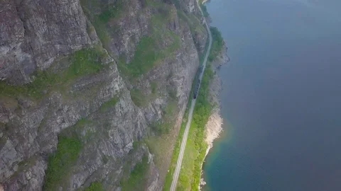 ProRes. Steam train passes through the mountains along the shore. Stock Footage 84367208