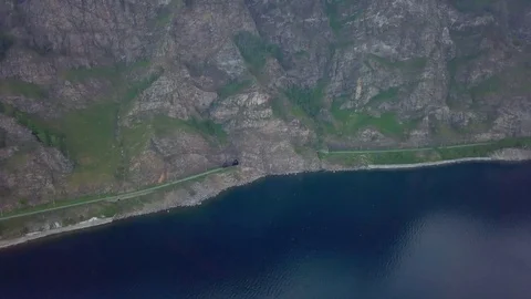 ProRes. Steam train passes through the mountains along the shore. Stock Footage 84368615
