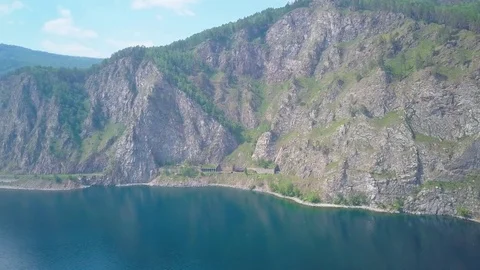 ProRes. Steam train passes through the mountains along the shore. Stock Footage 84369374