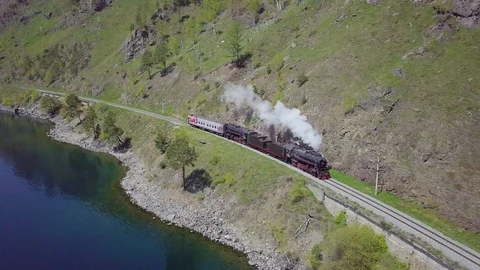ProRes. Steam train passes through the mountains along the shore. Stock Footage 91202068
