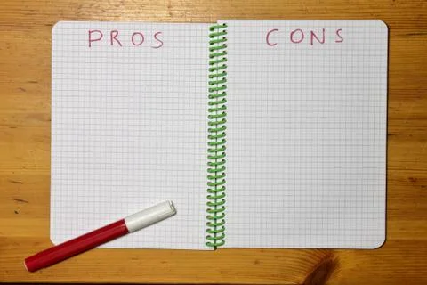 Pros Cons list in a checkered notebook and red marker Stock Photos