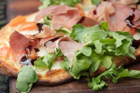 Prosciutto, arugula and cheese flatbread dish baked until crispy and browned Stock Photos