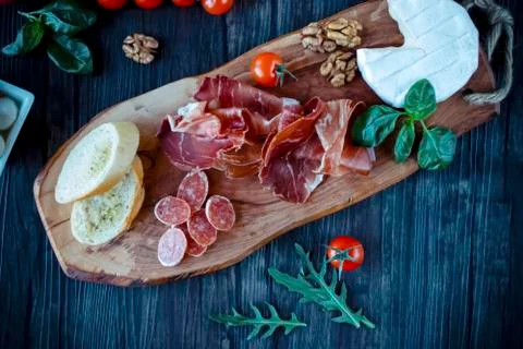Prosciutto, bread, olives, walnut, mozzarella, salami, basil and cherry tomat Foto stock