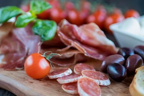 Prosciutto, bread, olives, walnut, mozzarella, salami, basil and cherry tomat Foto stock