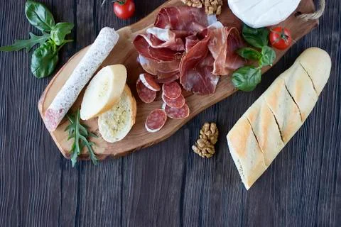 Prosciutto, bread, walnut, mozzarella, salami, basil and cherry tomatoes on Stock Photos