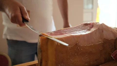 Prosciutto dry-cured ham being sliced with long knife Stock Footage 119393165