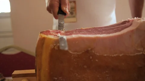 Prosciutto dry-cured ham being sliced with long knife Stock Footage 119393241
