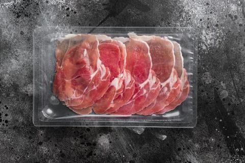Prosciutto pack, on black dark stone table background, top view flat lay, wit Foto stock