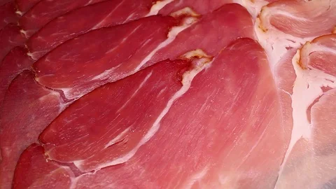 Prosciutto pork ham dry sliced red meat closeup texture video on rolling Stock Footage 104325916