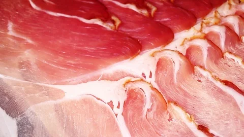 Prosciutto pork ham dry sliced red meat closeup texture video on rolling Stock Footage 104326052