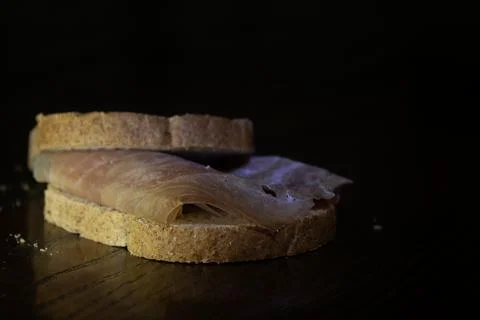 Prosciutto sandwich on dark background Stock Photos