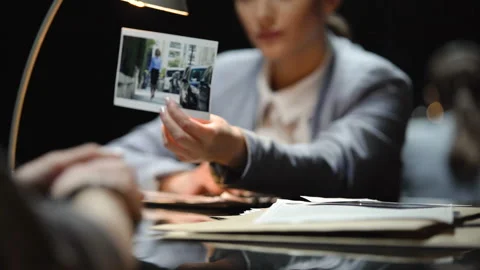 Prosecutor interrogating suspect, showing photo of victim, search for evidence Stock Footage 86154615