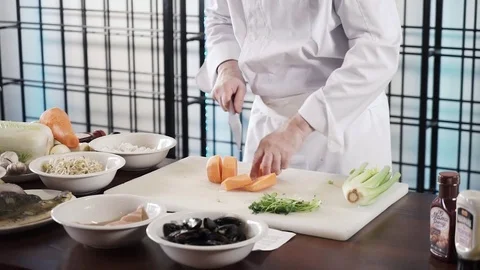 Proseffional chef hands is cutting carrot on his own modern kitchen in slow Stock Footage 73211511