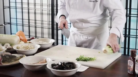 Proseffional chef hands is cutting celery on his own modern kitchen in slow Stock Footage 73211592