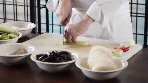 Proseffional chef hands is cutting celery on his own modern kitchen in slow Stock Footage 73213720