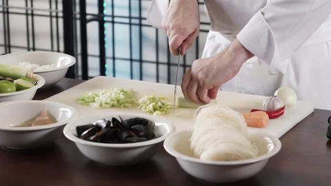 Proseffional chef hands is cutting celery on his own modern kitchen in slow Stock Footage 73213843