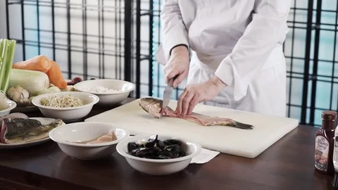 Proseffional chef hands is cutting Fish on his own modern kitchen in slow motion Stock-Footage 73211257